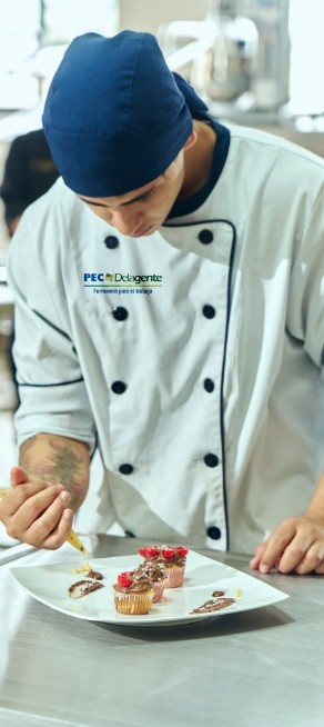Estudiante del PEC Politécnico Empresarial Colombiano en clase de gastronomía, decorando postres en el taller de cocina.